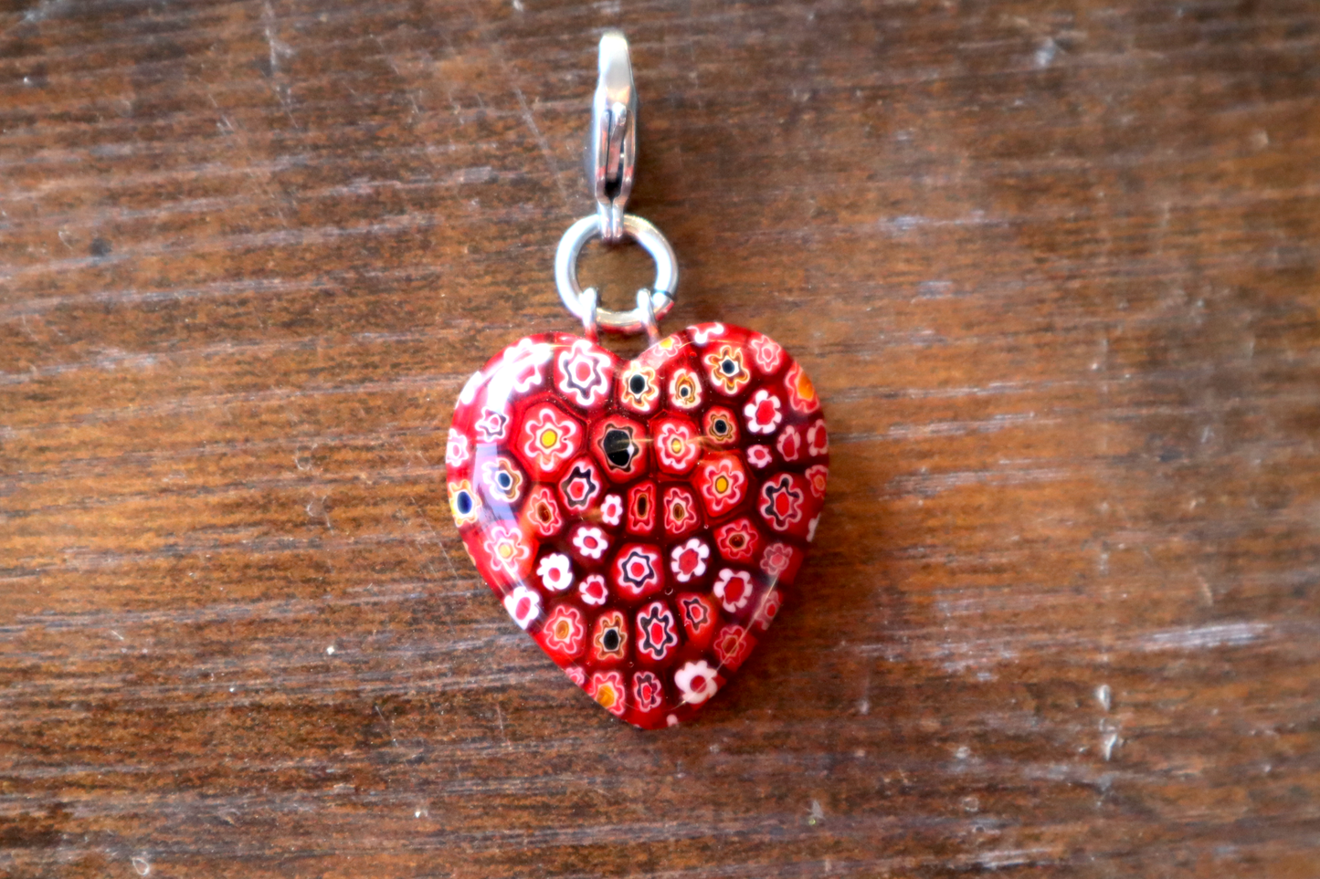 Heart-shaped pendant with floral pattern on a wooden surface