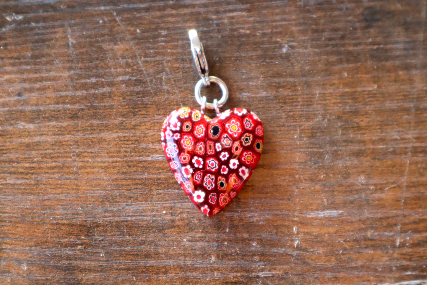 Heart-shaped pendant with floral pattern on a wooden surface