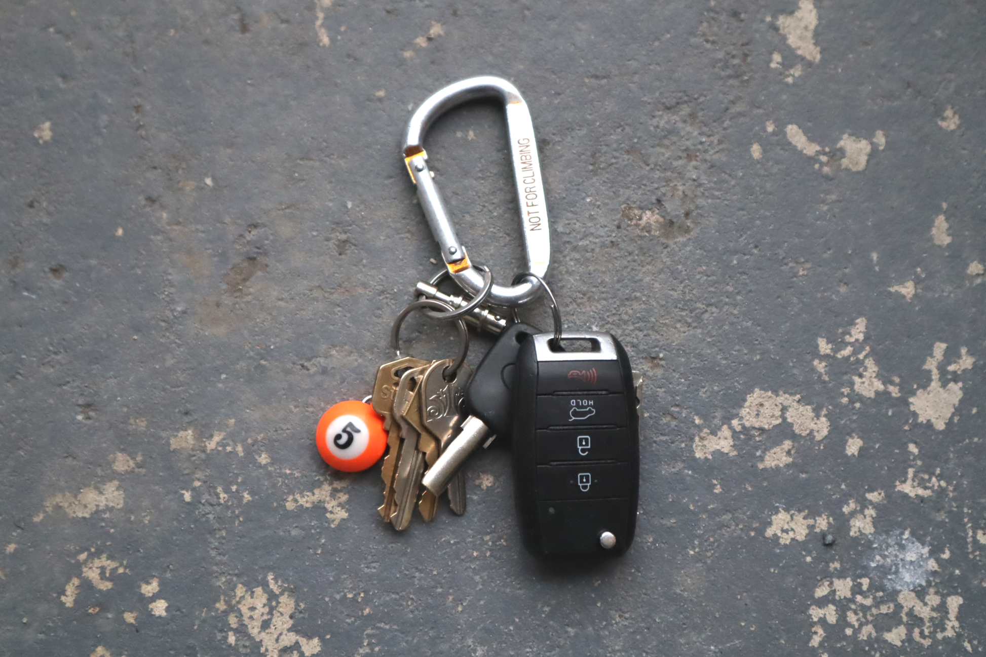 Keychain with keys and a car key fob on a textured surface