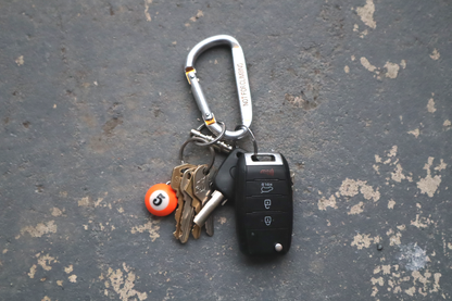 Keychain with keys and a car key fob on a textured surface