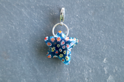 Blue star-shaped pendant with floral pattern on a gray background