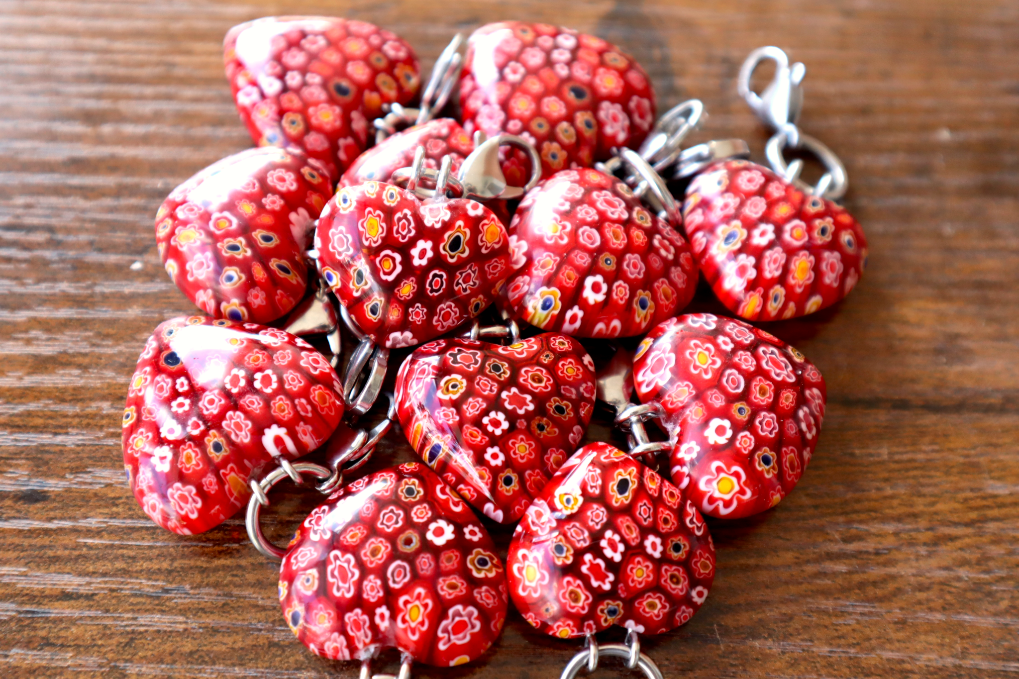 Red floral keychains on a wooden surface